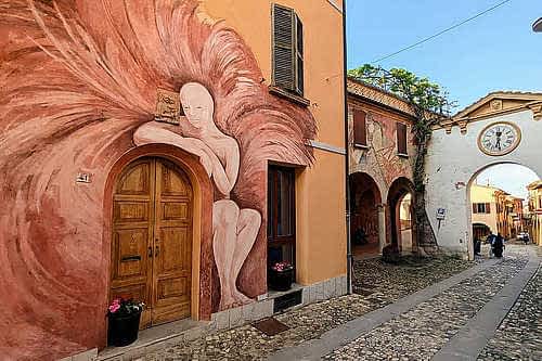 [title] - Manchmal sind es die Orte, die man gar nicht groß auf dem Schirm hat, die am meisten überraschen. Genau so ging es uns mit Dozza, einem kleinen Dorf in den Hügeln der Emilia-Romagna, das mit seinen bemalten Fassaden einer Kunstagalerie gleicht. 