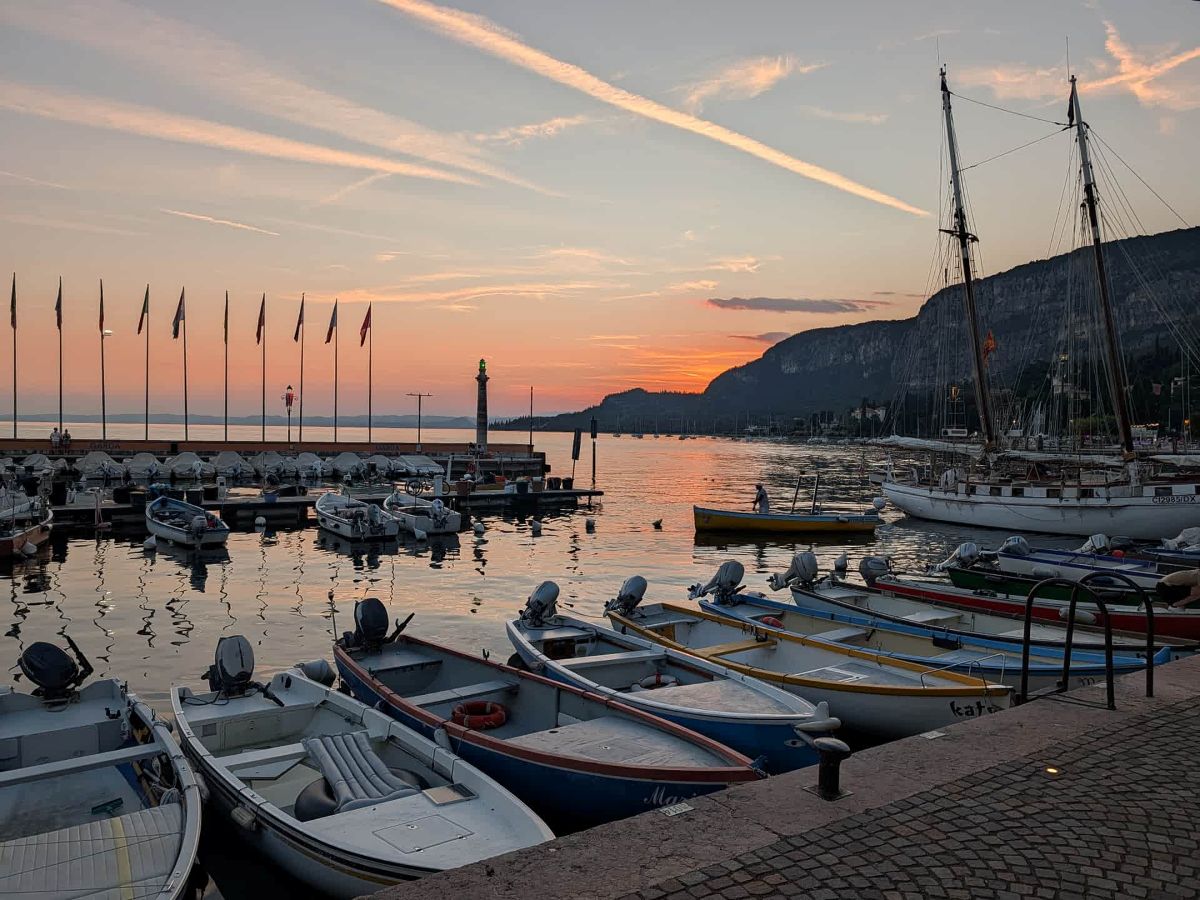 Hafen von Garda am Gardasee bei Sonnenuntergang mit Booten und Bergkulisse