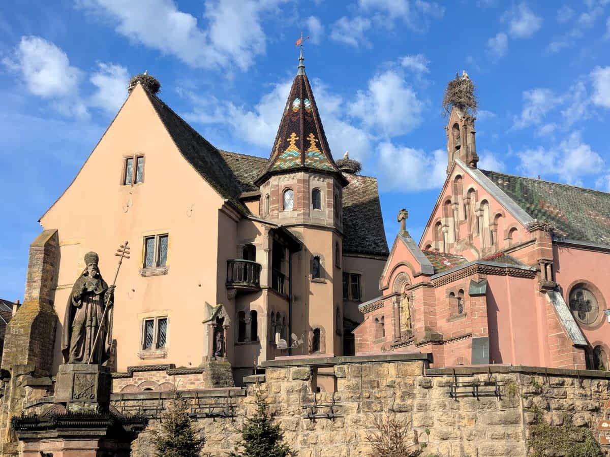 Die Kapelle von Eguisheim und die Burgmauer mit mehreren Storchennestern auf den Giebeln und Türmen. Die Kapelle von Eguisheim und die Burgmauer mit mehreren Storchennestern auf den Giebeln und Türmen.
