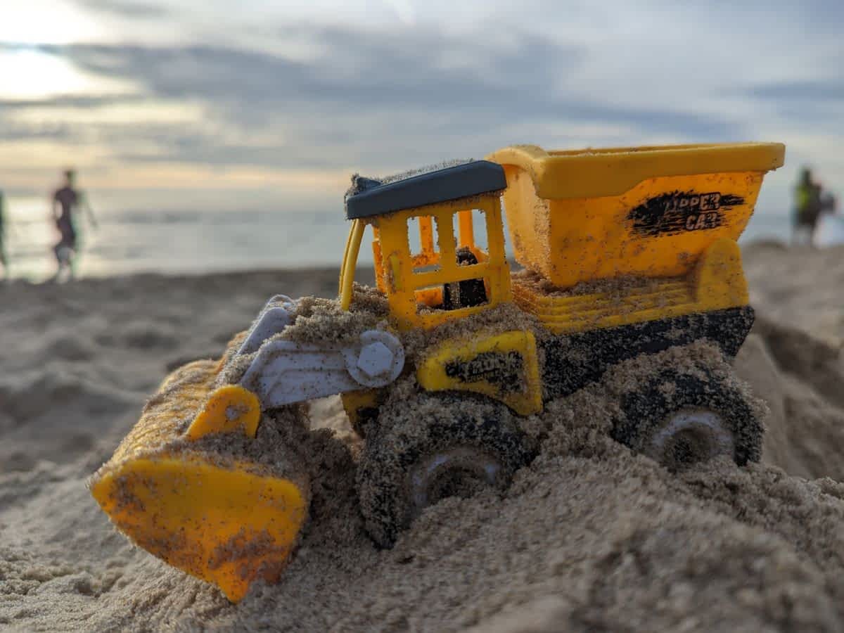 Ein Spielzeugbagger im Sand